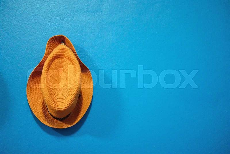 Orange hat on the blue wall background, stock photo