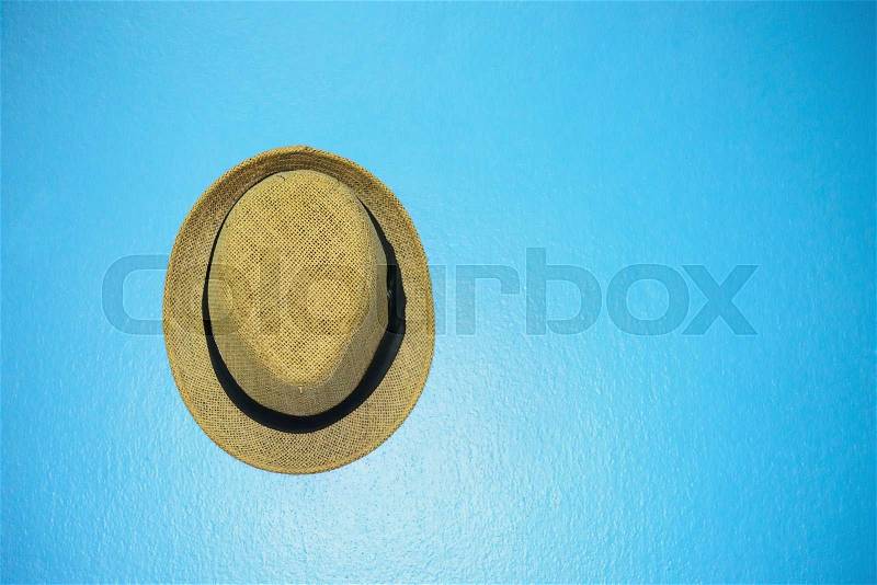 Vintage hat with black ribbon on blue vintage wall , stock photo