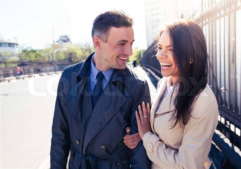 Portrait of a young laughing couple walking outdoors, stock photo