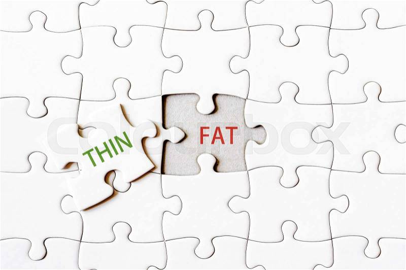 Missing jigsaw puzzle piece with word THIN, covering text FAT. Business concept image for completing the final puzzle piece, stock photo