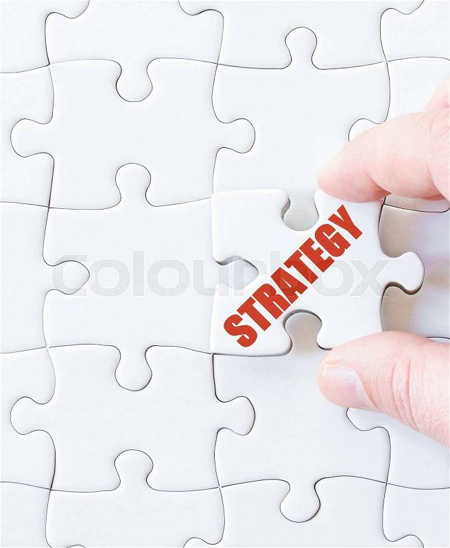 Missing jigsaw puzzle piece with word STRATEGY. Business concept image for completing the puzzle, stock photo