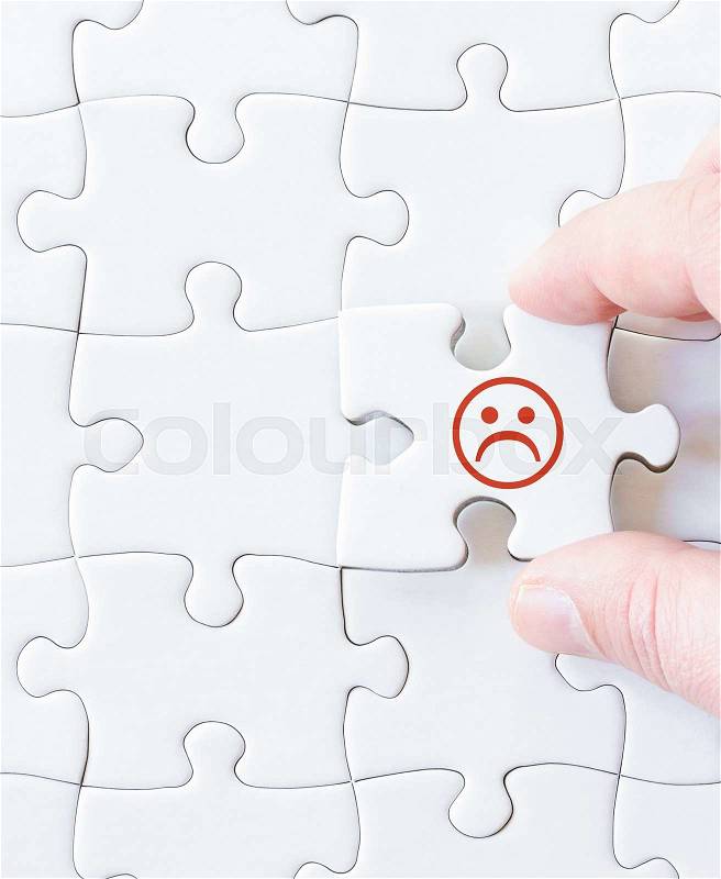 Missing jigsaw puzzle piece with sad emoticon face. Business concept image for completing the puzzle, stock photo