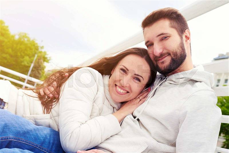 Urban photo of smiley couple in love looking at camera, stock photo