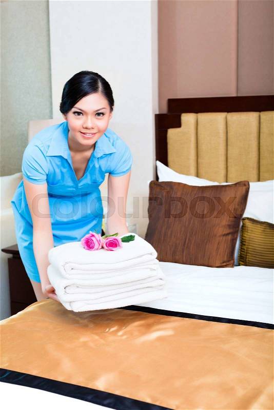 Chambermaid cleaning in Asian hotel room, stock photo