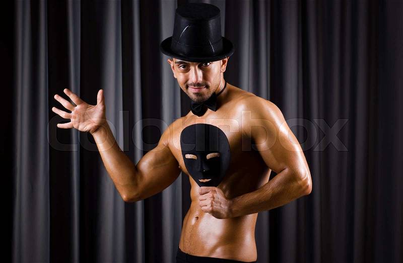 Muscular actor with theatrical mask, stock photo