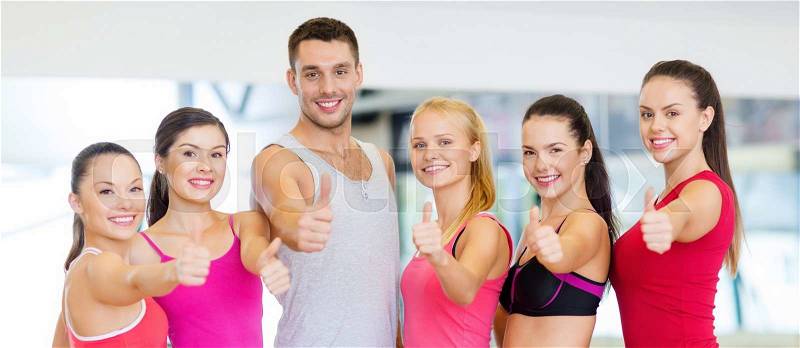 Fitness, sport, training, gym and lifestyle concept - group of happy people in the gym showing thumbs up, stock photo