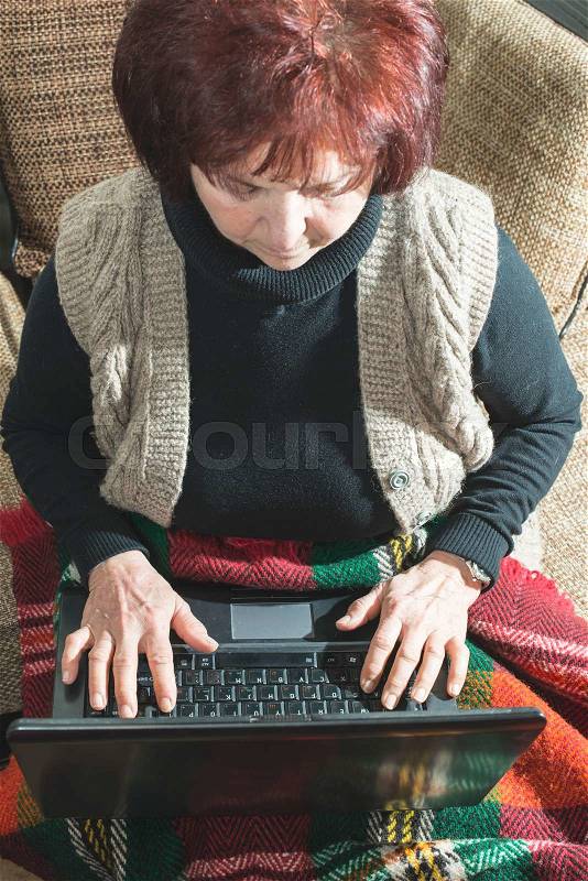Old women using old laptop, stock photo
