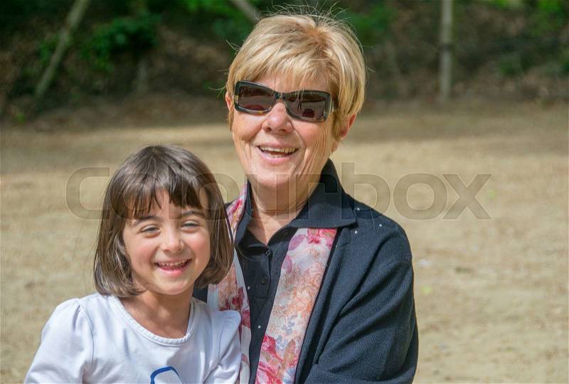 Grandmother and nephew enjoying outdoor life in a city park, stock photo