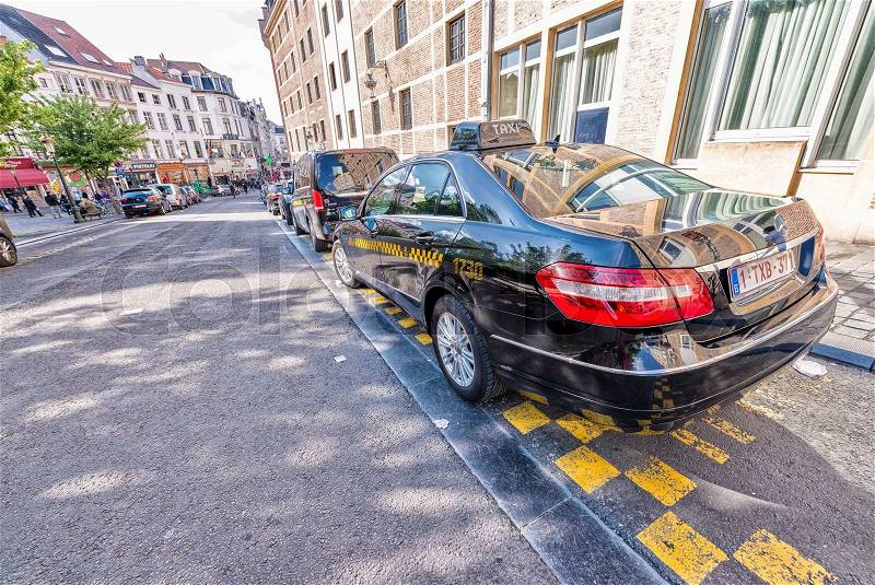BRUSSELS - MAY 1, 2015: City taxi awaits customers along the street. Only taxis bearing the official Brussels taxi sign are licensed, stock photo