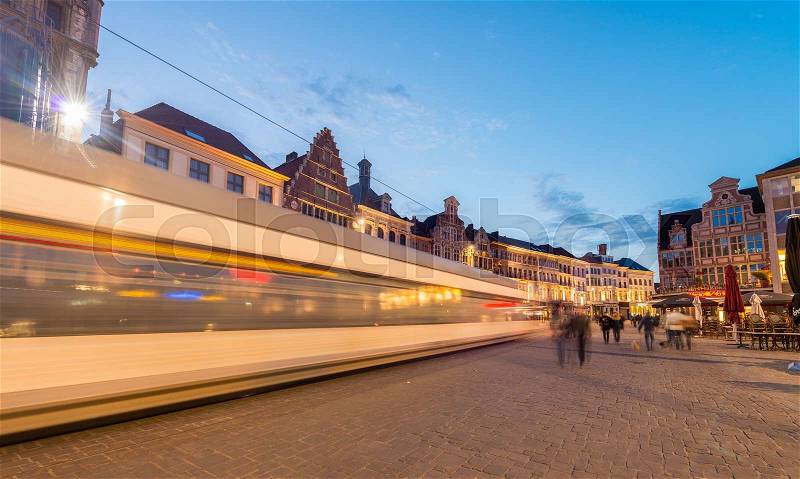 GENT, BELGIUM - APRIL 20, 2015: Tram moves fast in city center. Gent is a busy city which hosts many students and tourists spending the night outside, stock photo