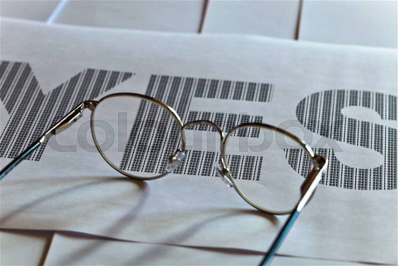 Glasses and printed text on white paper, focus on text, stock photo