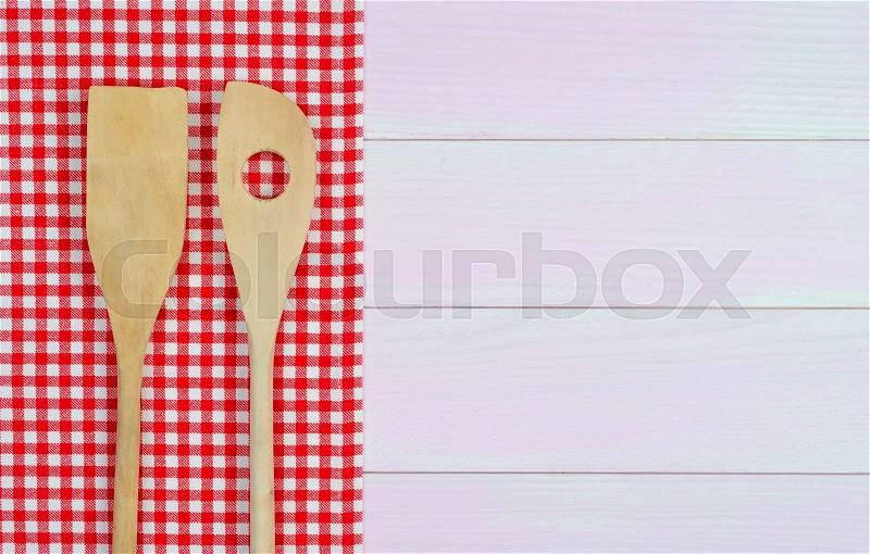 Kitchenware on white and red towel over wooden kitchen table. View from above, stock photo