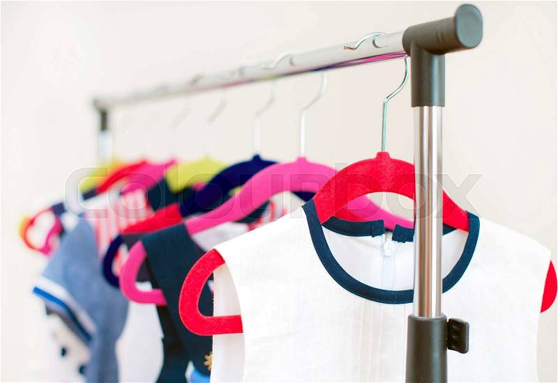 Lots of colorful dresses on hangers in shop, stock photo