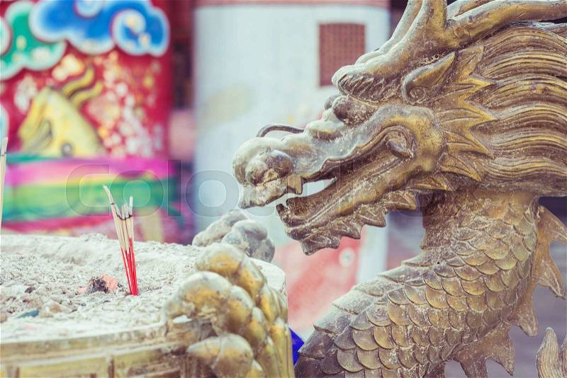 Close up steel dragon statue on incense bucket in Chinese temple, stock photo