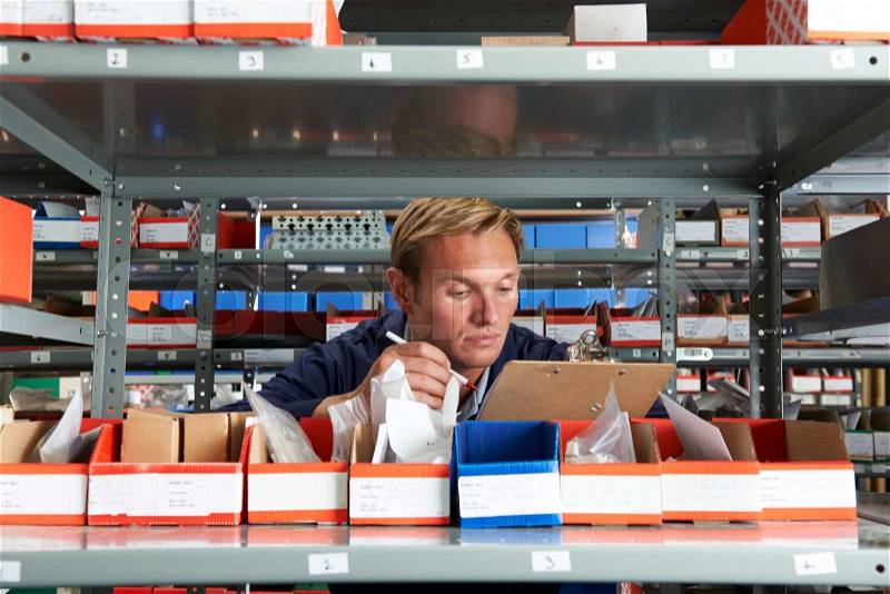 Factory Worker In Store Room Checking Stock, stock photo