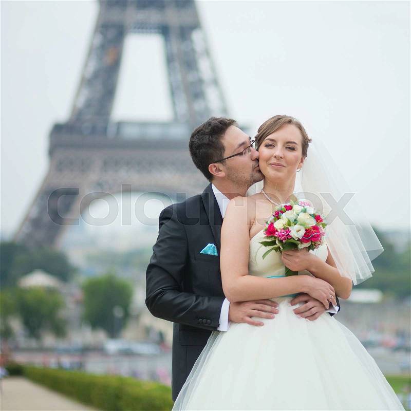 Happy just married couple near the Eiffel tower in Paris, stock photo