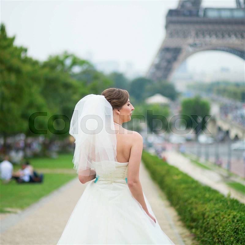 Happy young beautiful bride in Paris, near the Eiffel tower , stock photo