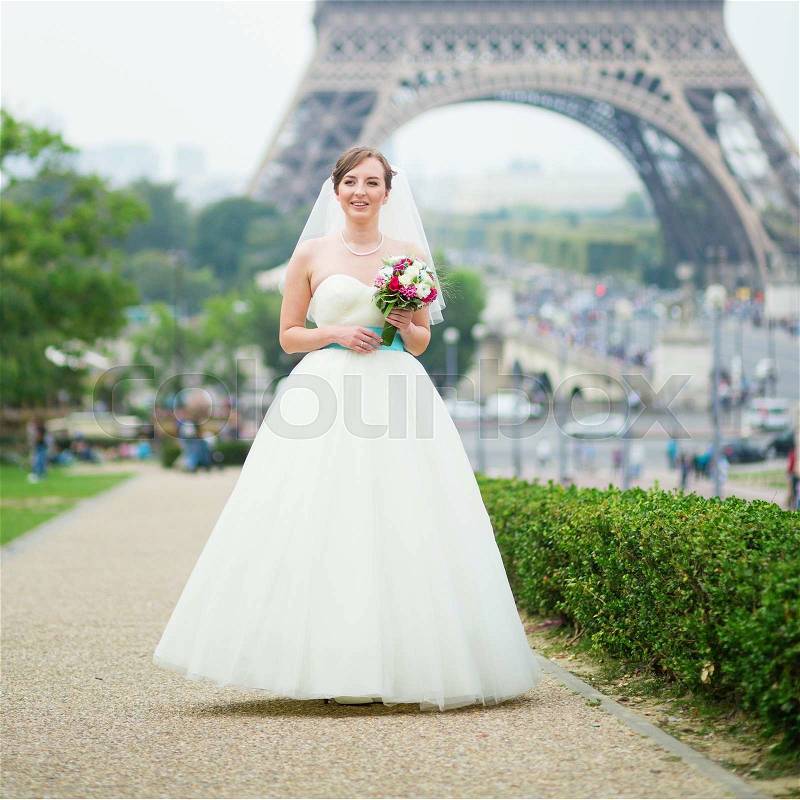 Happy young beautiful bride in Paris, near the Eiffel tower, stock photo