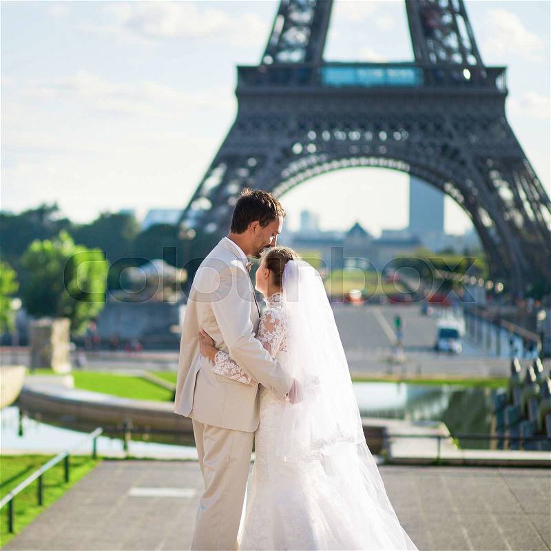 Beautiful just married couple in Paris near the Eiffel tower, stock photo