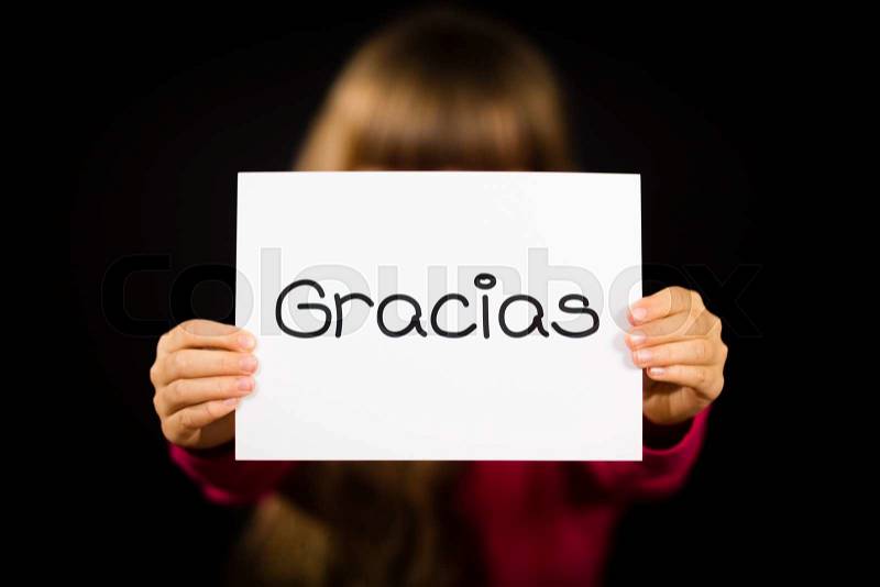Studio shot of child holding a sign with Spanish word Gracias - Thank You, stock photo