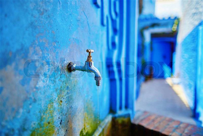 Small fountain with drinkable water on a street in Medina of Chefchaouen, Morocco, small town in northwest Morocco known for its blue buildings, stock photo