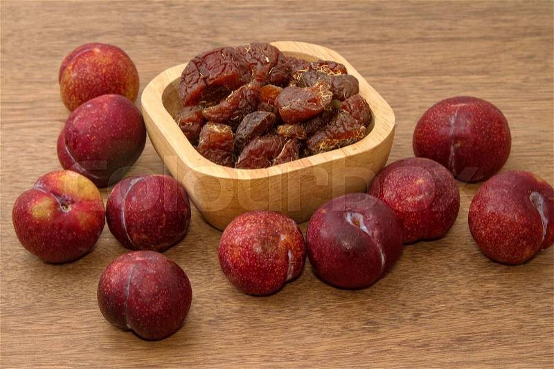 Dried plums and fresh plums on the wooden table, stock photo