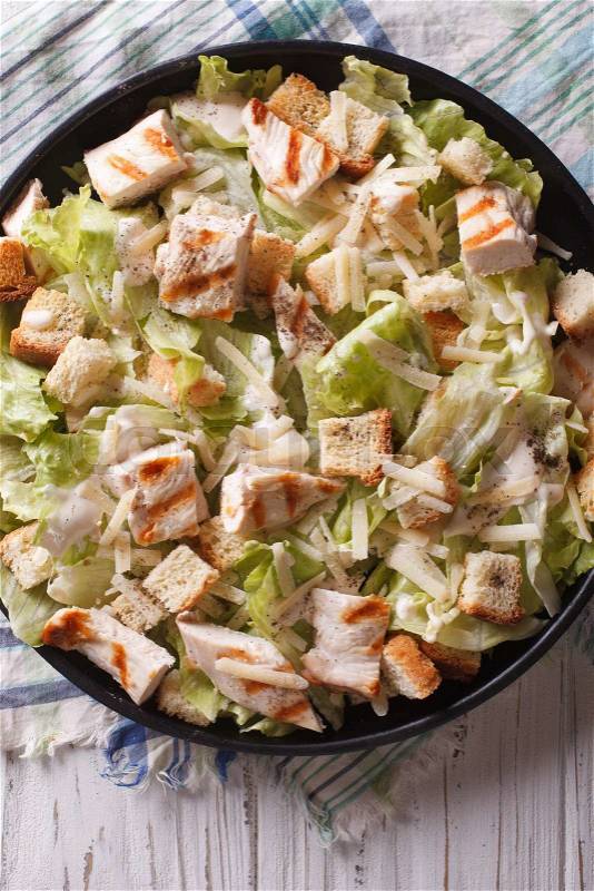 Caesar salad with chicken closeup on the plate. vertical view from above\, stock photo