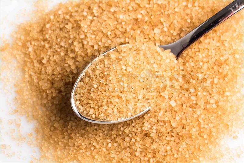Brown sugar in a spoon on white background, stock photo