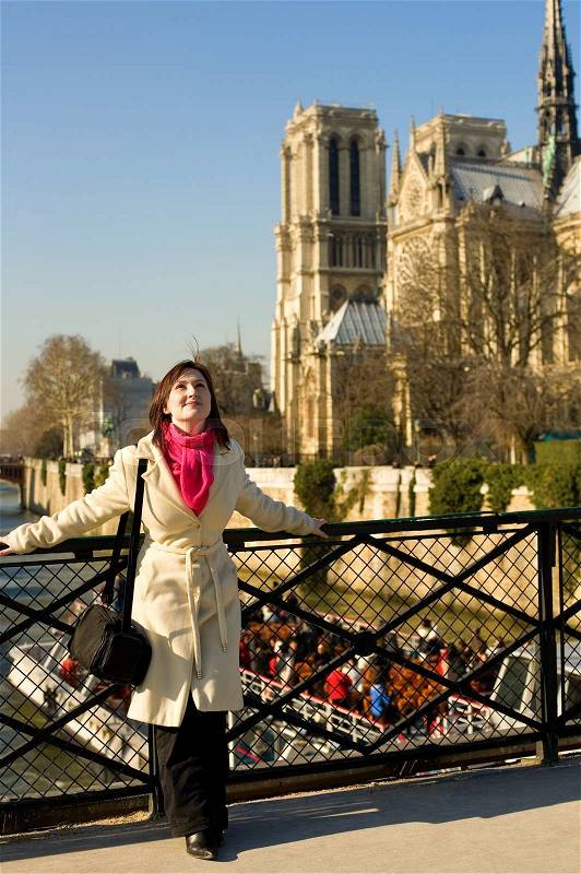 Happy beautiful woman in Paris near Notre-Dame de Paris, enjoying warm spring day, stock photo