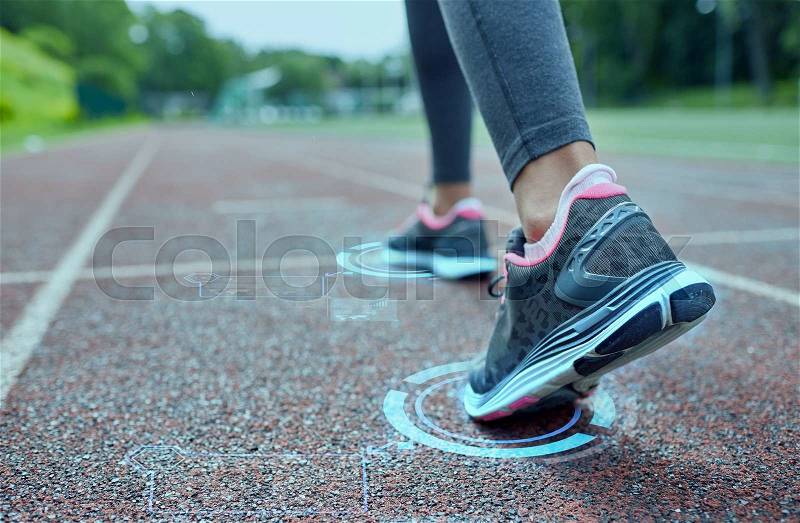 Fitness, sport, training, people and lifestyle concept - close up of woman feet running on track from back with futuristic holograms, stock photo