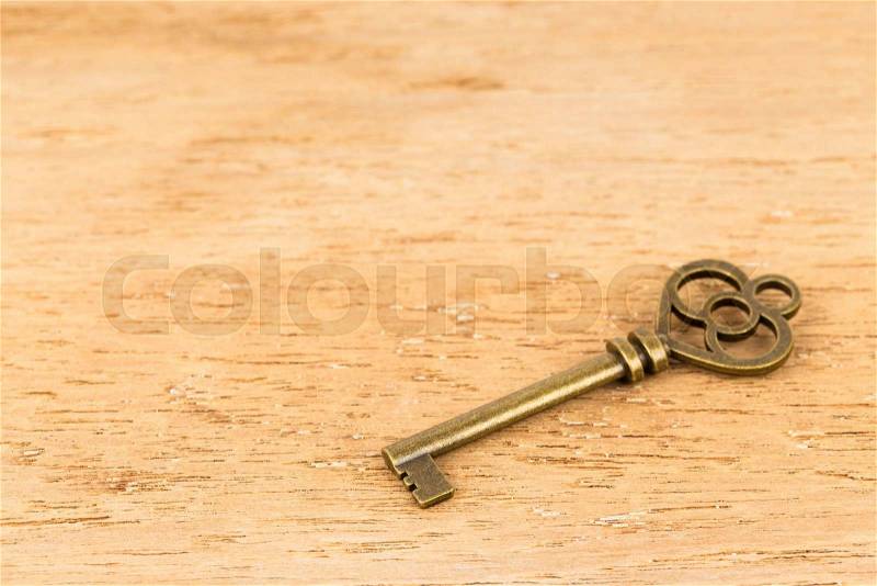 Antique key on wooden background, stock photo