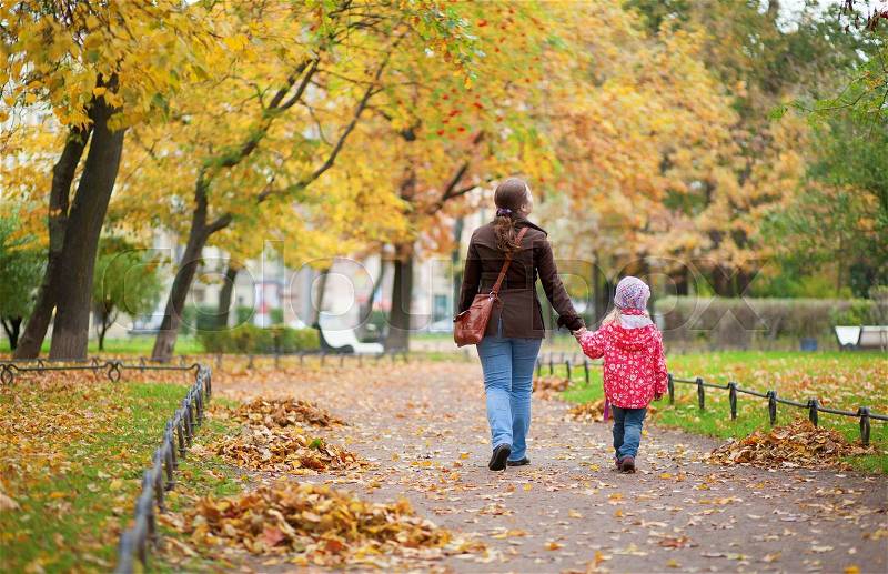 Mother and daughter walking together at beautiful autumn day, stock photo