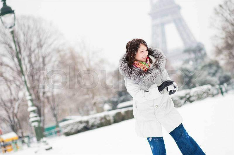 Girl playing snowball in Paris on a winter day, stock photo