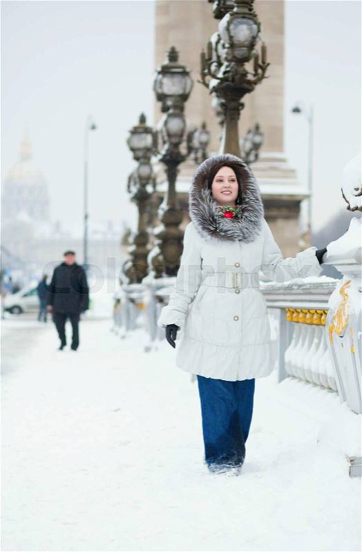 Beautiful young woman in Paris on a snowy day, stock photo