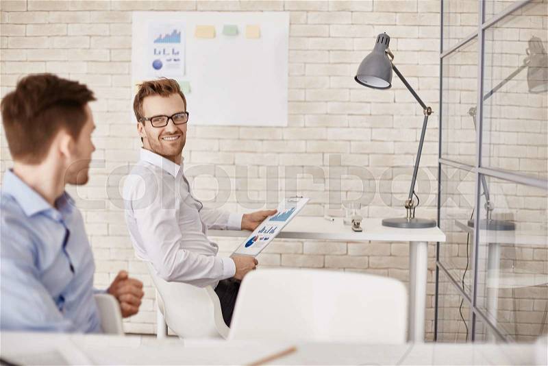 Successful businessman listening to colleague in office, stock photo