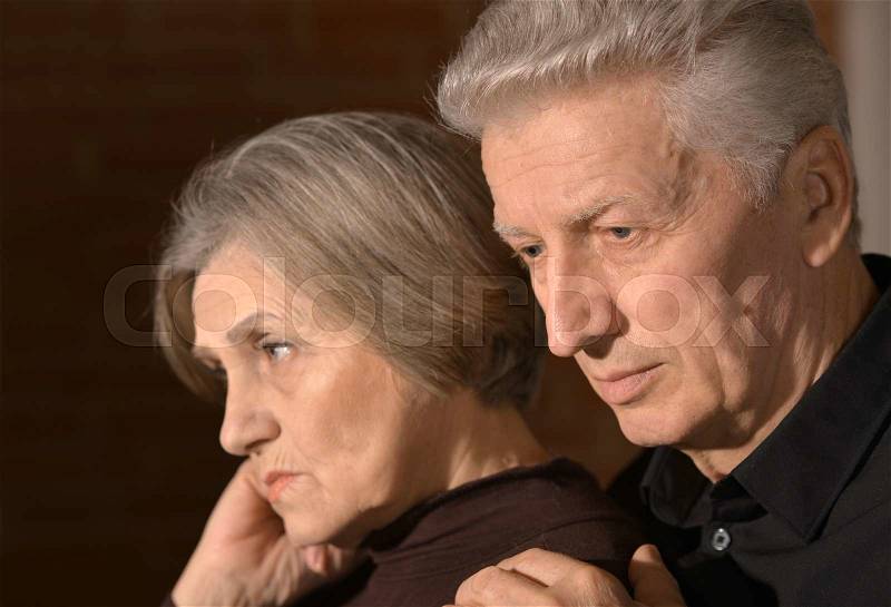 Portrait of a sad elder couple at home, stock photo