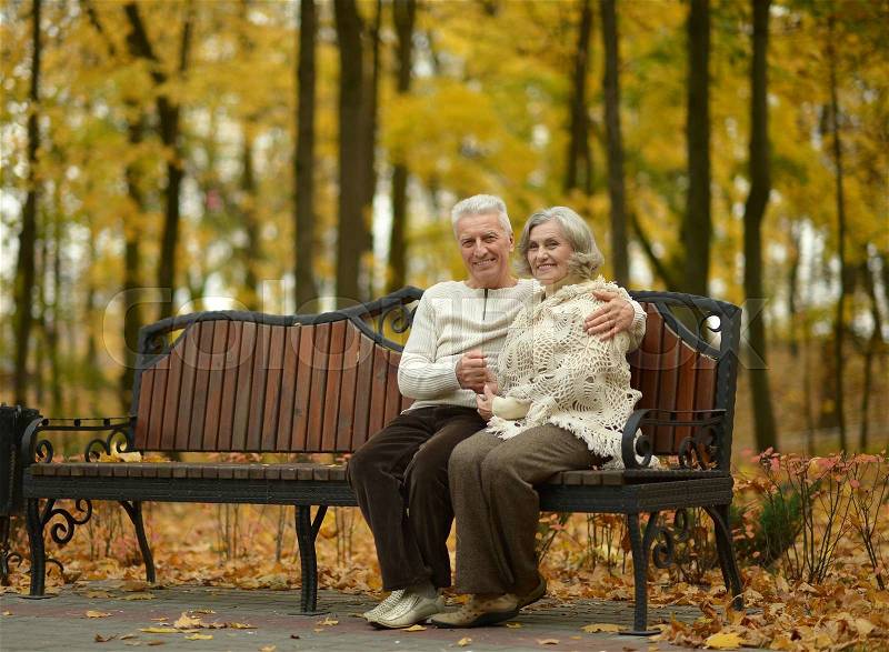 Happy senior couple relaxing in autumn park, stock photo