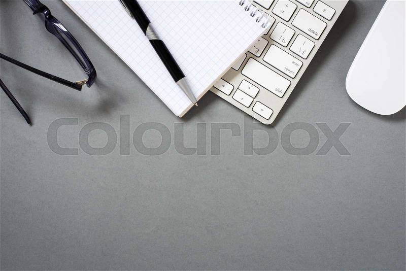High Angle View of Mac Computer Keyboard and Mouse with Paper, Pen and Eyeglasses on Grey Desk with Ample Copy Space, stock photo