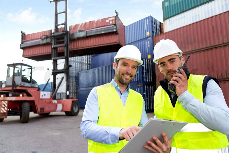 View of a Dock worker and supervisor checking containers data , stock photo