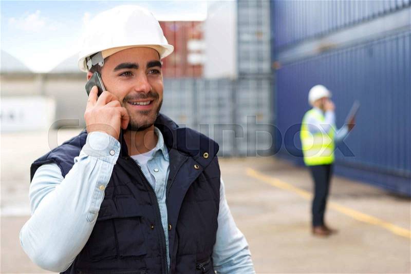 View of a Young Attractive docker using mobile phone at work, stock photo