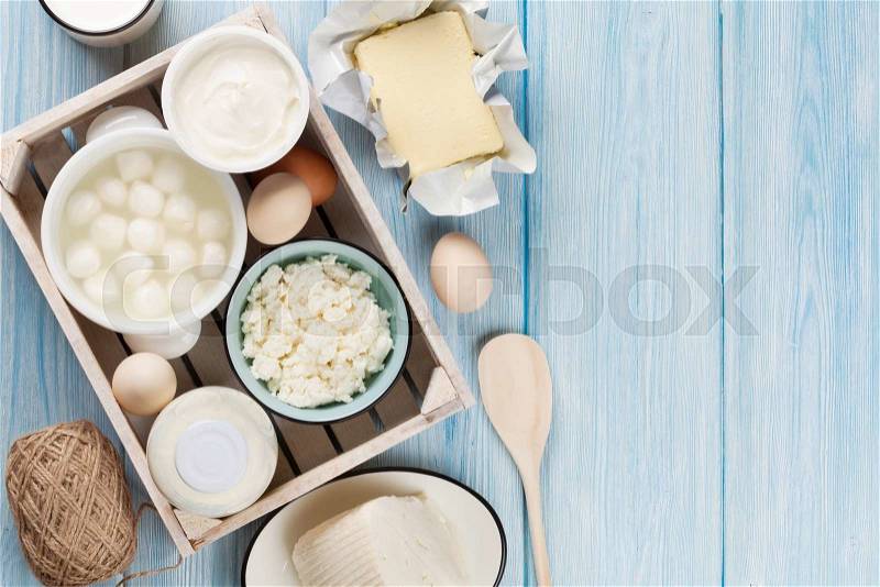 Dairy products on wooden table. Sour cream, milk, cheese, egg, yogurt and butter. Top view with copy space, stock photo