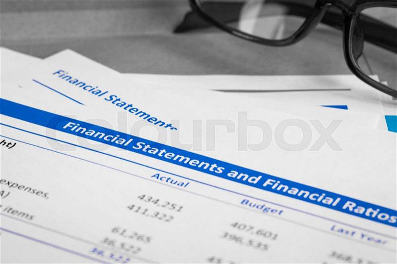 Financial statement letter on brown envelope and eyeglass, business concept; document is mock-up, stock photo