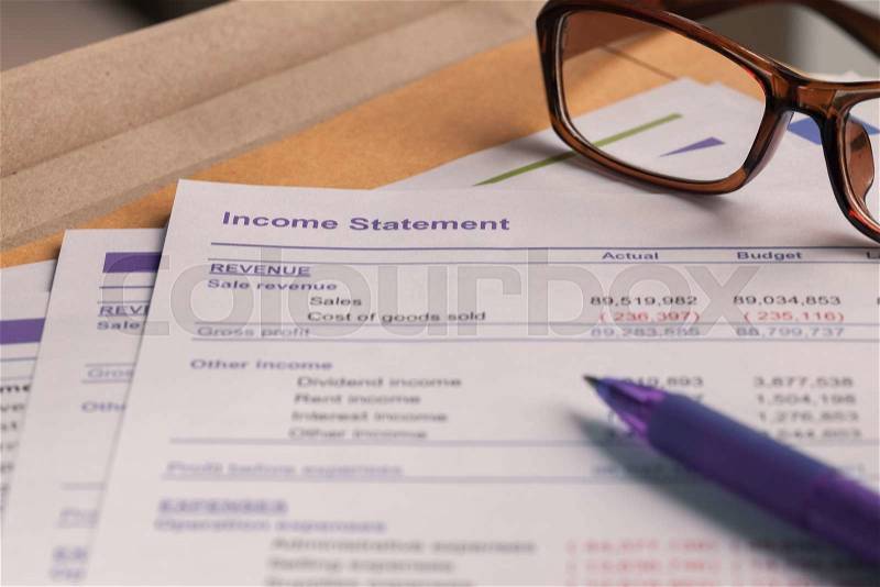 Income statement letter on brown envelope and eyeglass, pen, business concept; document is mock-up, stock photo