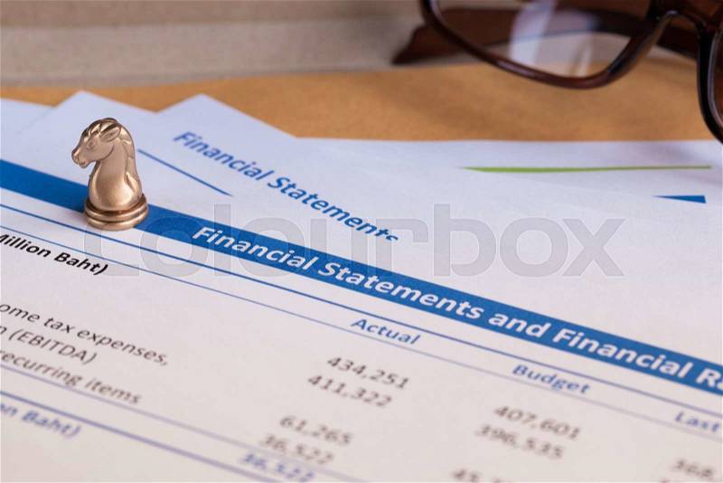 Financial statement letter on brown envelope and eyeglass, business concept; document is mock-up, stock photo