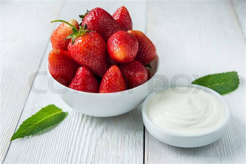 Fresh red strawberries with cream om white wood table. Easy dietary breakfast, stock photo