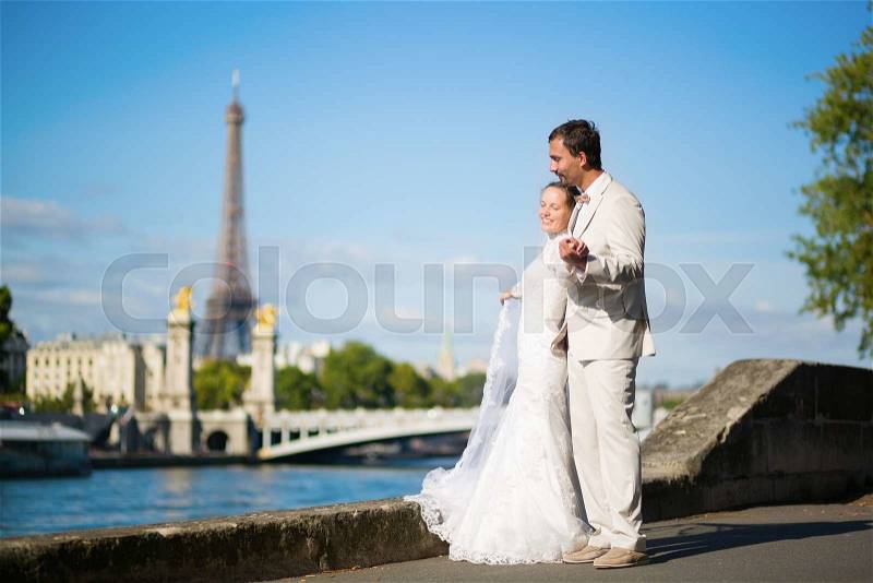 Beautiful just married couple in Paris near the Eiffel tower , stock photo