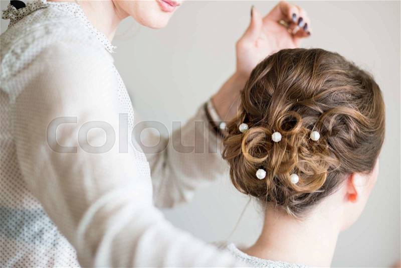 Young bride getting her hair done before wedding, stock photo