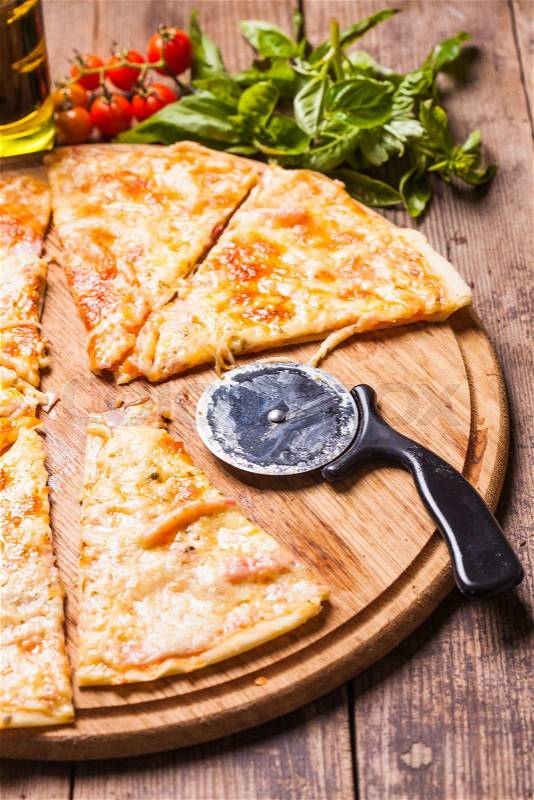 Pizza Margarita on the wooden board and pizza cutter, stock photo