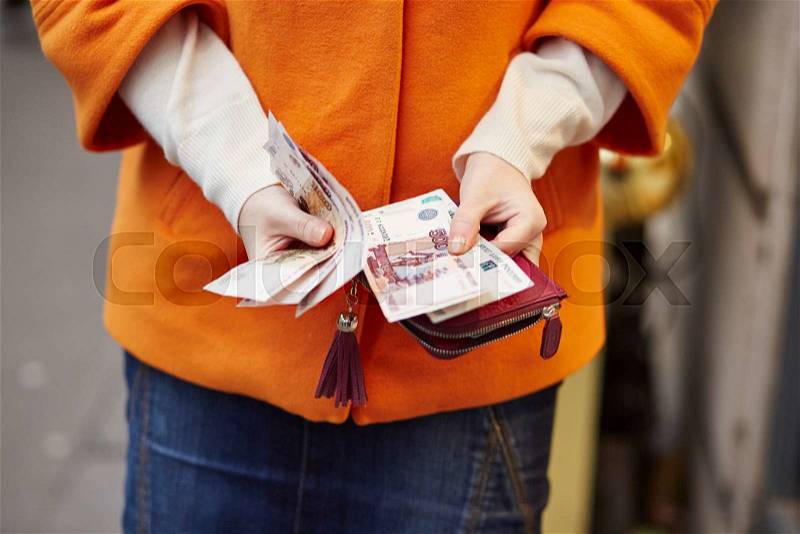 Woman hands holding purse with Russian roubles, financial crisis in Russia concept, stock photo