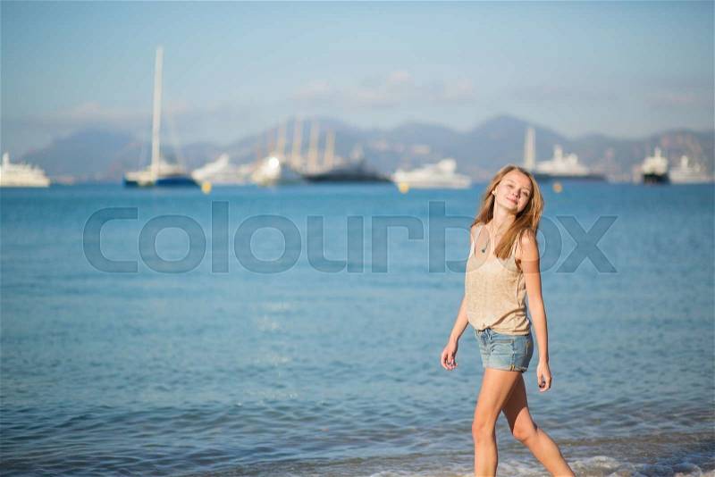 Beautiful young girl enjoying her vacation by the sea, stock photo